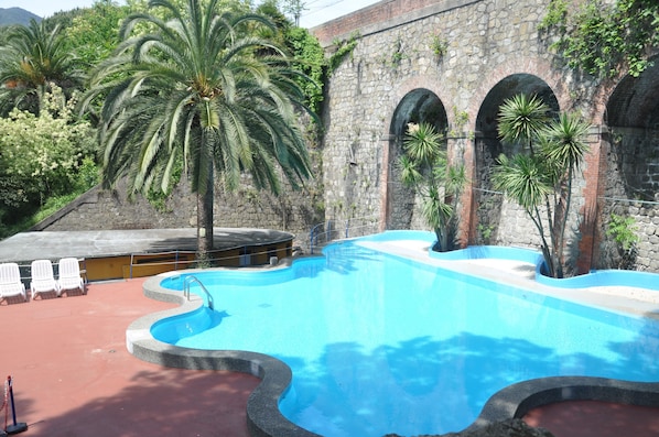 Piscine extérieure en saison, chaises longues
