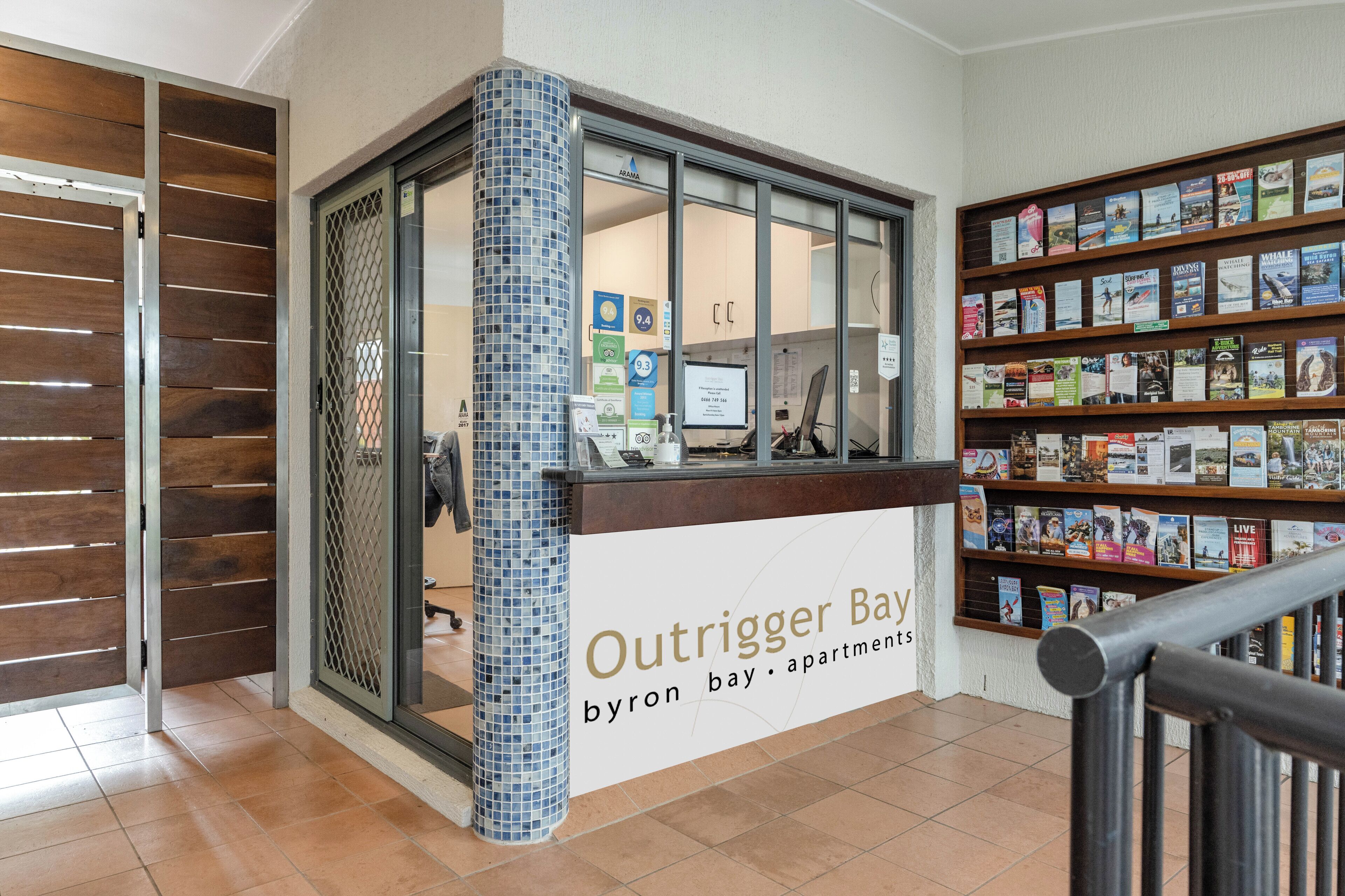 A reception desk with a sign for 'Outtrigger Bay byron bay apartments'.