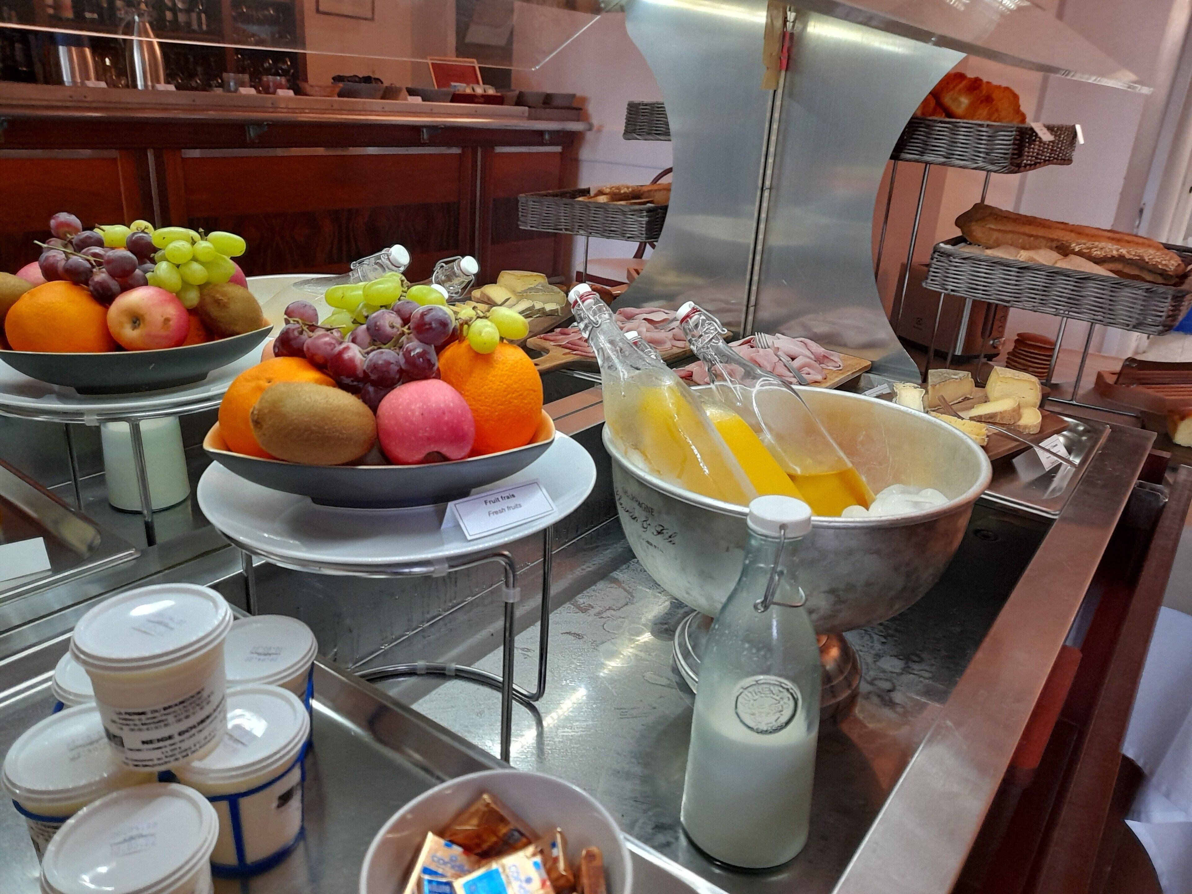A buffet setup with various food items including fruits, cheeses, and meats.