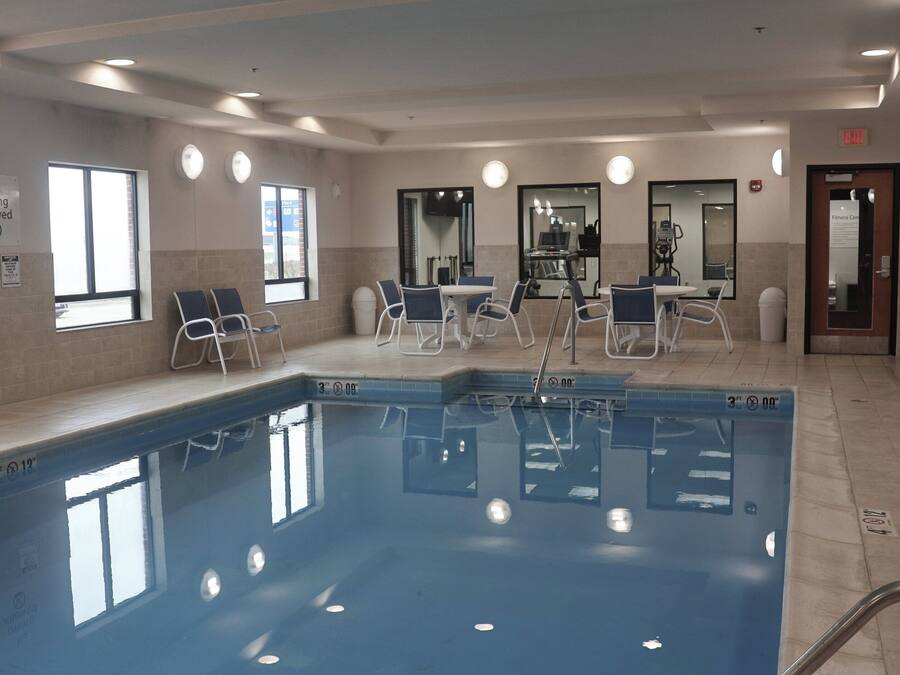 Una piscina interior con sillones de descanso, un gimnasio y un cartel que indica que no se permite bucear.
