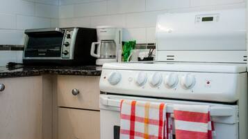 Una cocina equipada con microondas, cafetera y estufa.