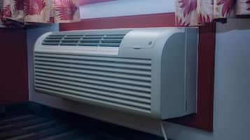 A wall-mounted air conditioner with a control panel and a power cord.