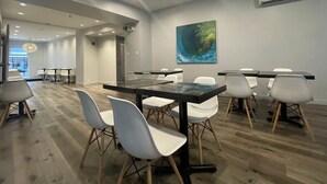 A conference room with a large table, white chairs, and a painting on the wall. - Hôtel du Nord (Québec City)