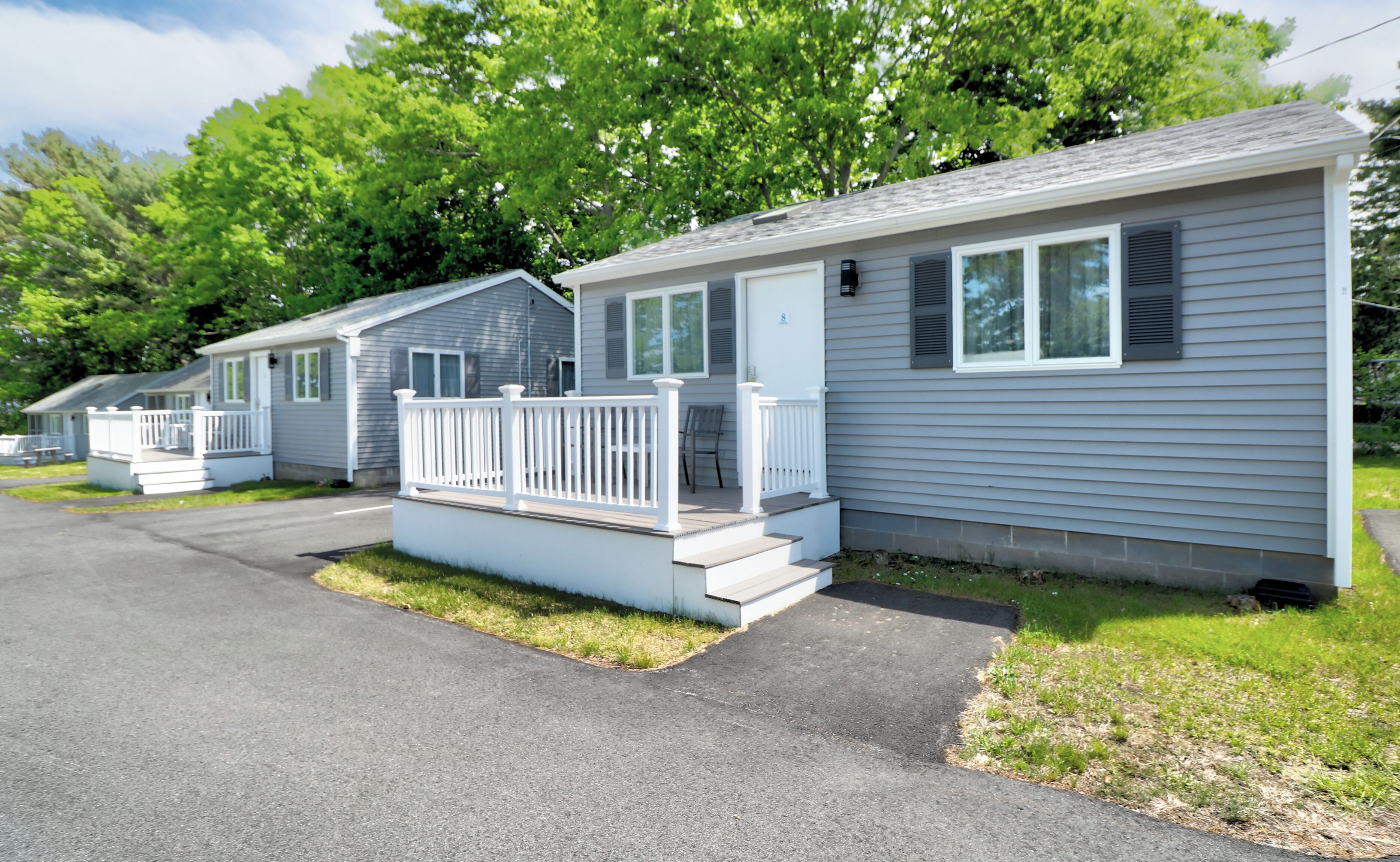 A row of mobile homes with white railings and steps leading to the front door.