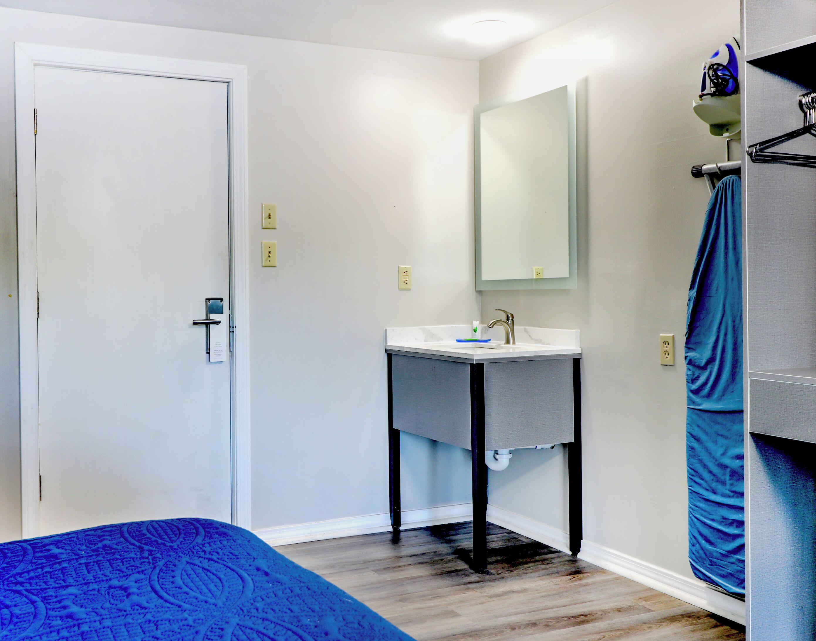 A bathroom with a white sink, a mirror, and a towel rack.