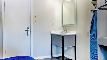 A bathroom with a white sink, a mirror, and a towel rack.