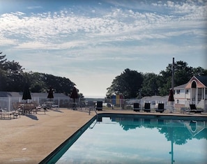 Una piscina al aire libre de temporada, sombrillas