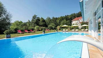 Alberca al aire libre, sombrillas en la alberca y camastros