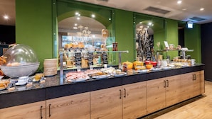 A buffet area with various food items and a large bowl of fruit. - Parkhotel Maximilian Ottobeuren Resort&Spa (Ottobeuren)