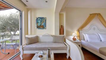 A room with a sofa, a bed, a table with a pitcher and cups, and a painting on the wall.