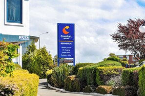 Placa do Comfort Hotel com comodidades como centro de eventos, carregamento para veículos elétricos, academia e restaurante e bar.