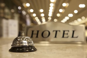 A hotel bell on a counter with a sign in the background. - Europa Hotel (Chisinau)