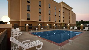 A hotel pool area with lounge chairs and a swimming pool.