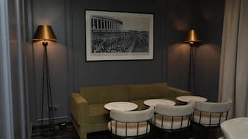 A room with a sofa, round tables, and two floor lamps.