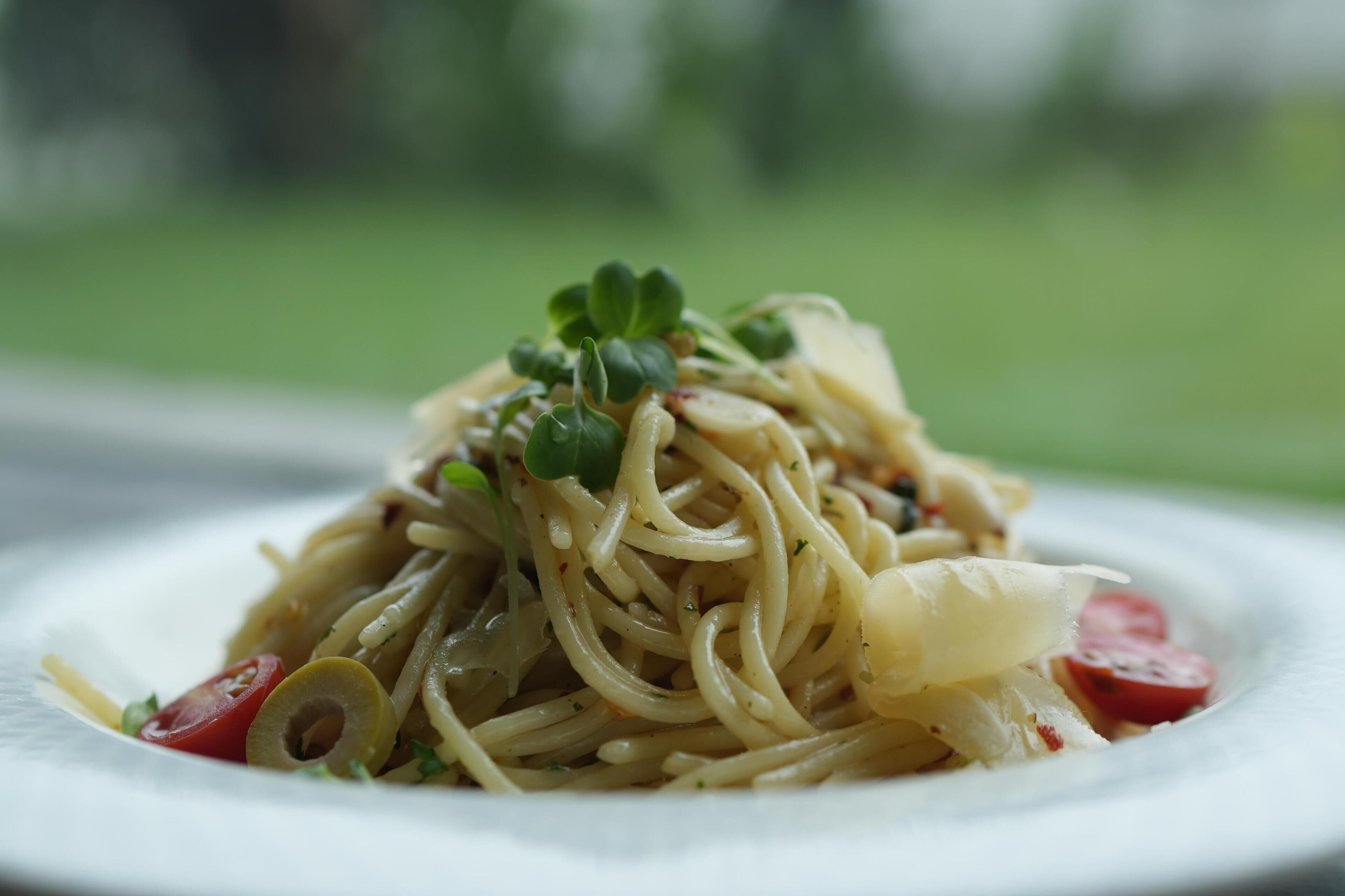 A plate of pasta with vegetables and herbs.