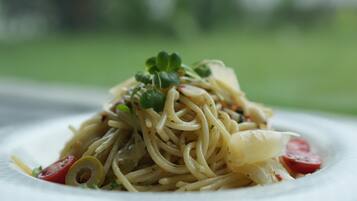 A plate of pasta with vegetables and herbs.