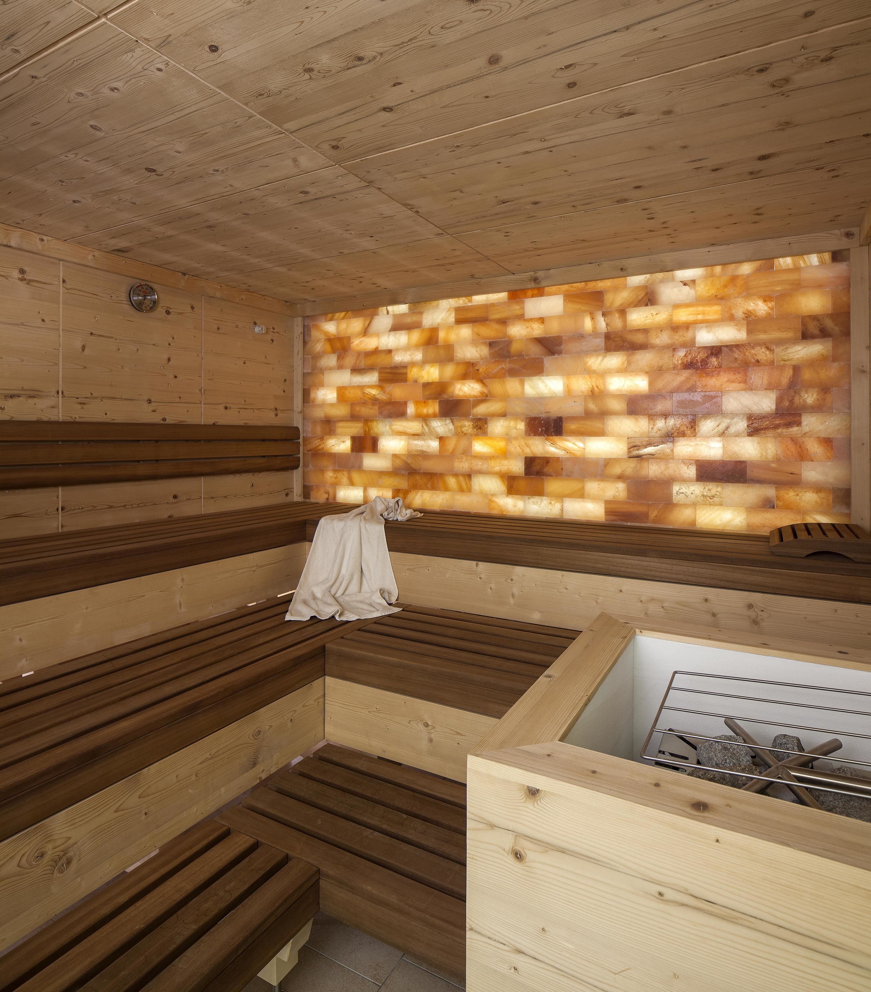 Una sauna con bancos de madera y una pared de vidrio.