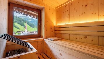 Een houten sauna met raam, banken en een handdoekrek.