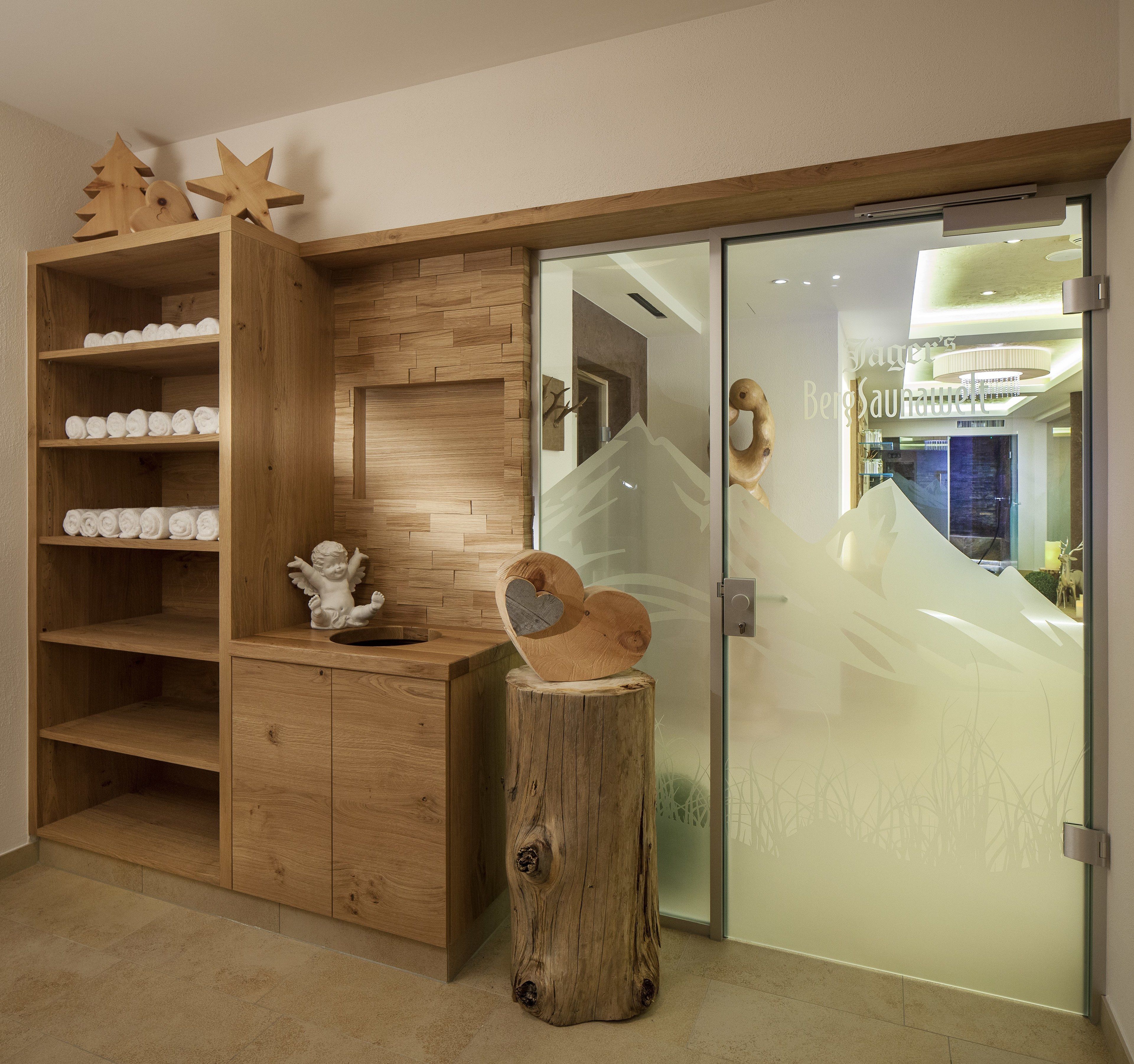 A wooden vanity with shelves, a mirror, and a wooden stump.