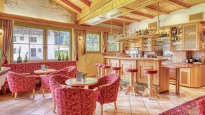 Eine gemütliche Bar mit Holztischen und einer Theke.