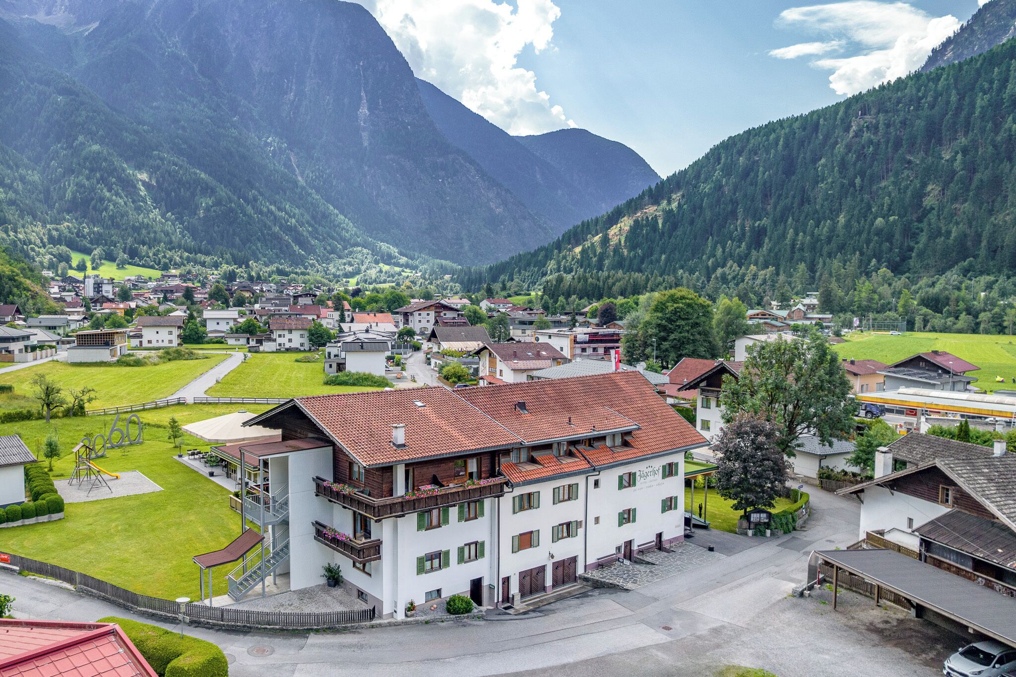 A mountain village with traditional architecture, a central square, and a playground.