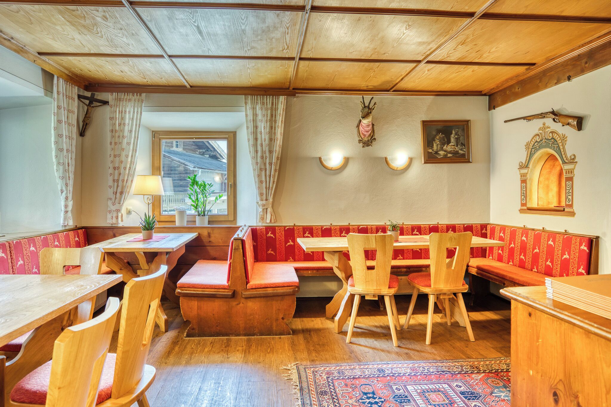 A traditional inn with wooden furniture, a bench seating area, and a rustic ceiling.