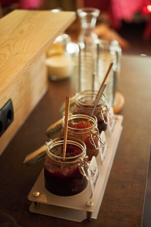 A counter with jars of jam and a candle.