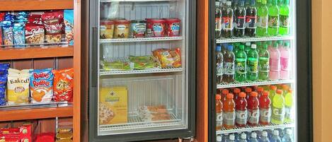 A vending machine with snacks and drinks, and a refrigerated display case with various food items.