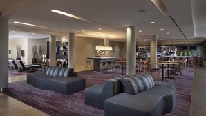 Un hall d’entrée spacieux avec un bar, des espaces aménagés pour s’asseoir et un design moderne.