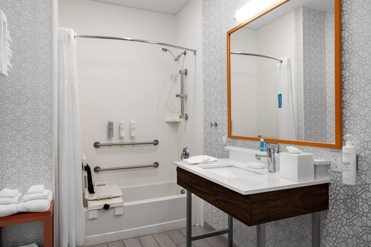 Ein modernes Badezimmer mit Dusche, Waschbecken und Spiegel.