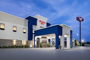 Un hotel Hampton Inn con fachada moderna, amplio acceso y exterior bien iluminado.