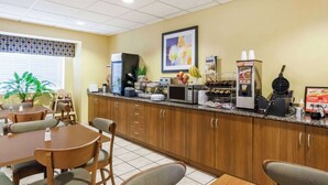 Un espace de restauration d’hôtel avec des meubles de rangement en bois, un comptoir de buffet et un coin café.