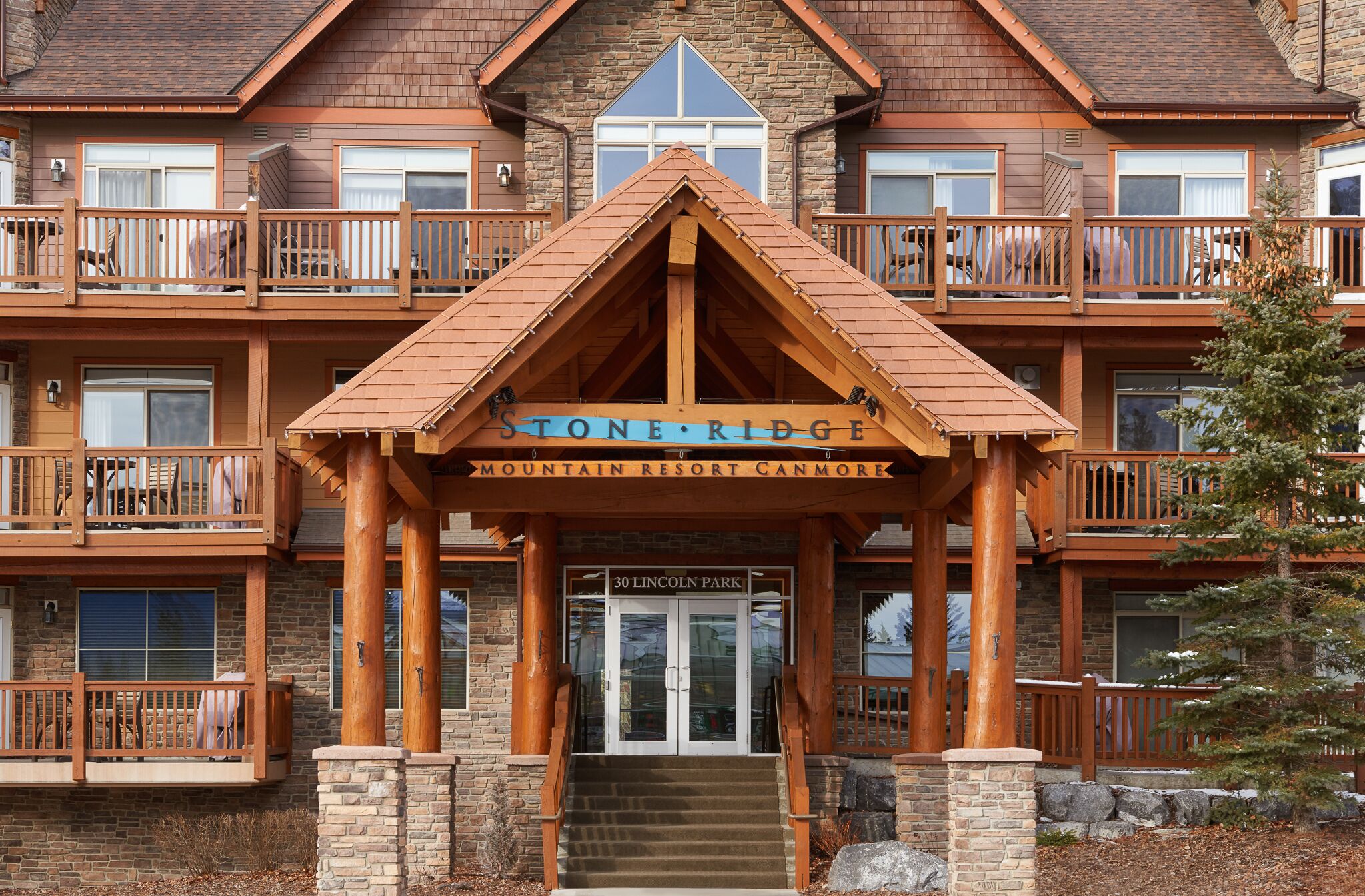 A multi-story lodge with a prominent entrance labeled "Stone Ridge Mountain Resort Canmore."