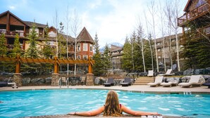 A pool area with lounge chairs and a view of lodge buildings. - Stoneridge Mountain Resort (Canmore)
