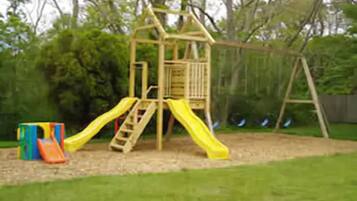 Une structure de jeux en bois, dotée de toboggans et d’une zone d’escalade.