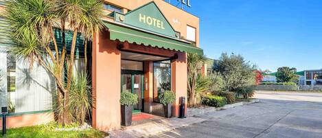 A hotel with a green awning and a sign that reads "HOTEL" above the entrance.