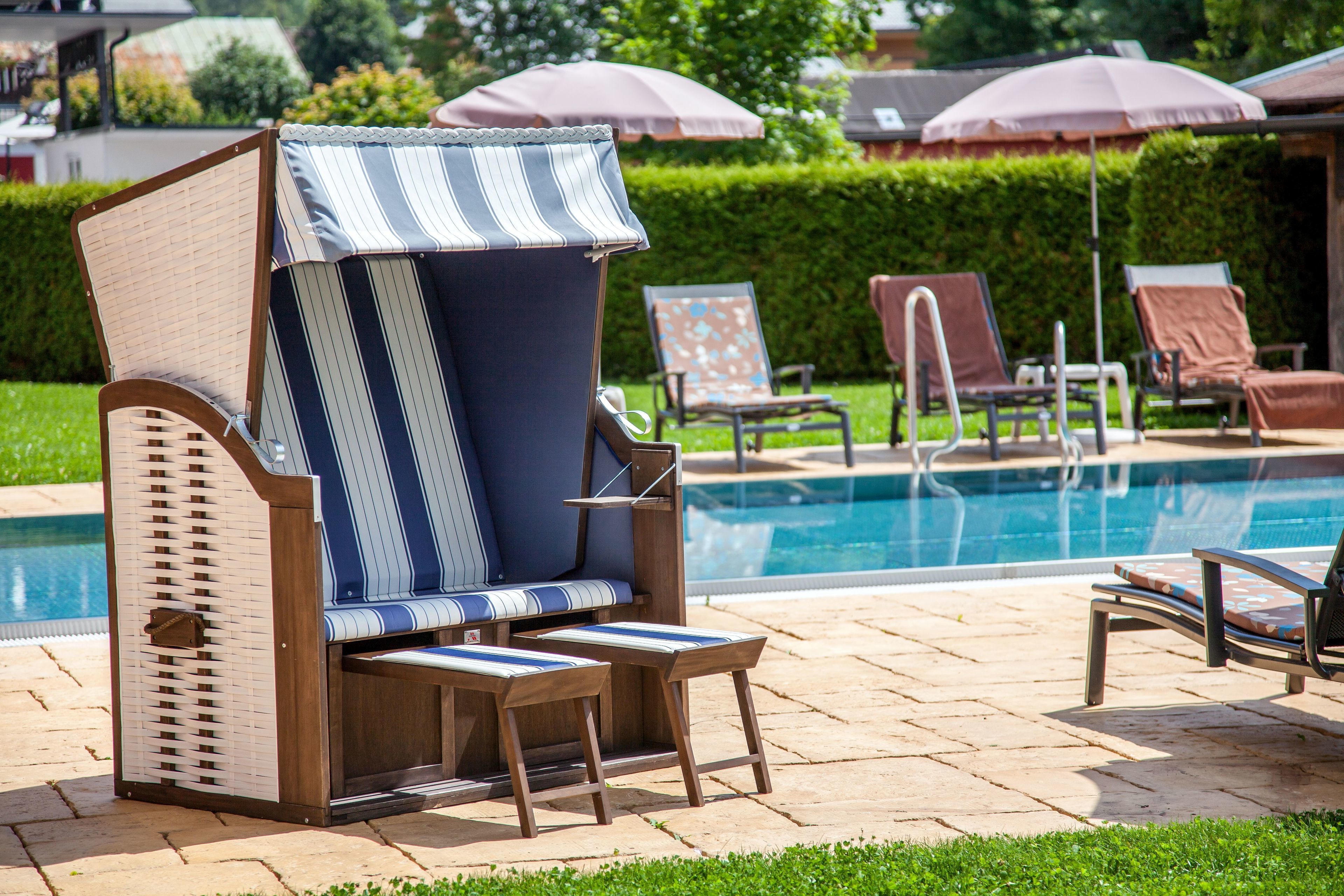A poolside area with lounge chairs and umbrellas.