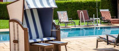 A poolside area with lounge chairs and umbrellas.