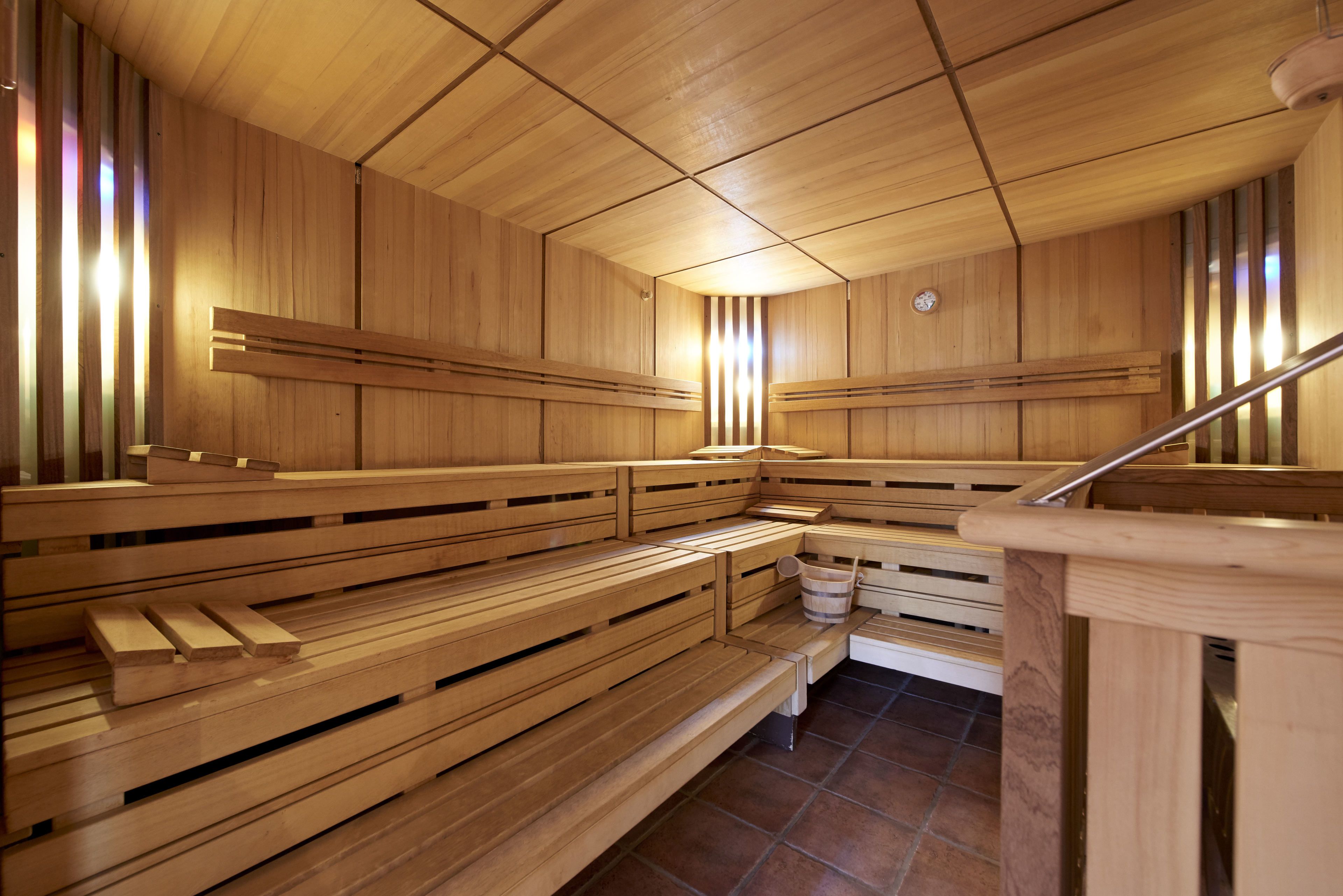Una sauna con bancos de madera y suelo de baldosas.