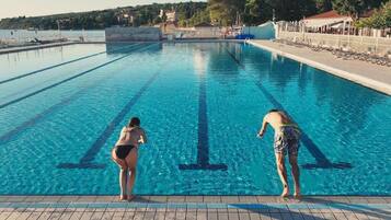 A swimming pool with clear water, marked lanes, and a tiled deck.