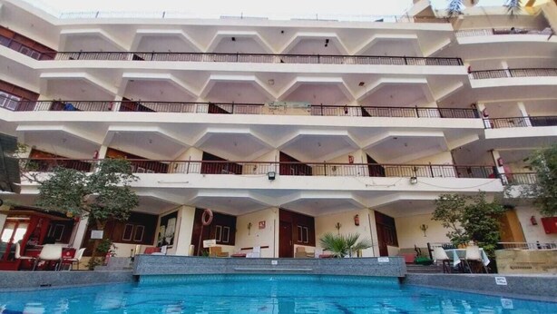 A multi-story hotel with a swimming pool in the foreground. - Rezeiky Hotel And Camp Luxor (Luxor)