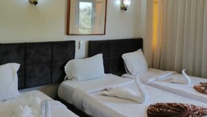 A hotel room with three beds, a ceiling fan, and wall-mounted air conditioning. - Rezeiky Hotel And Camp Luxor (Luxor)