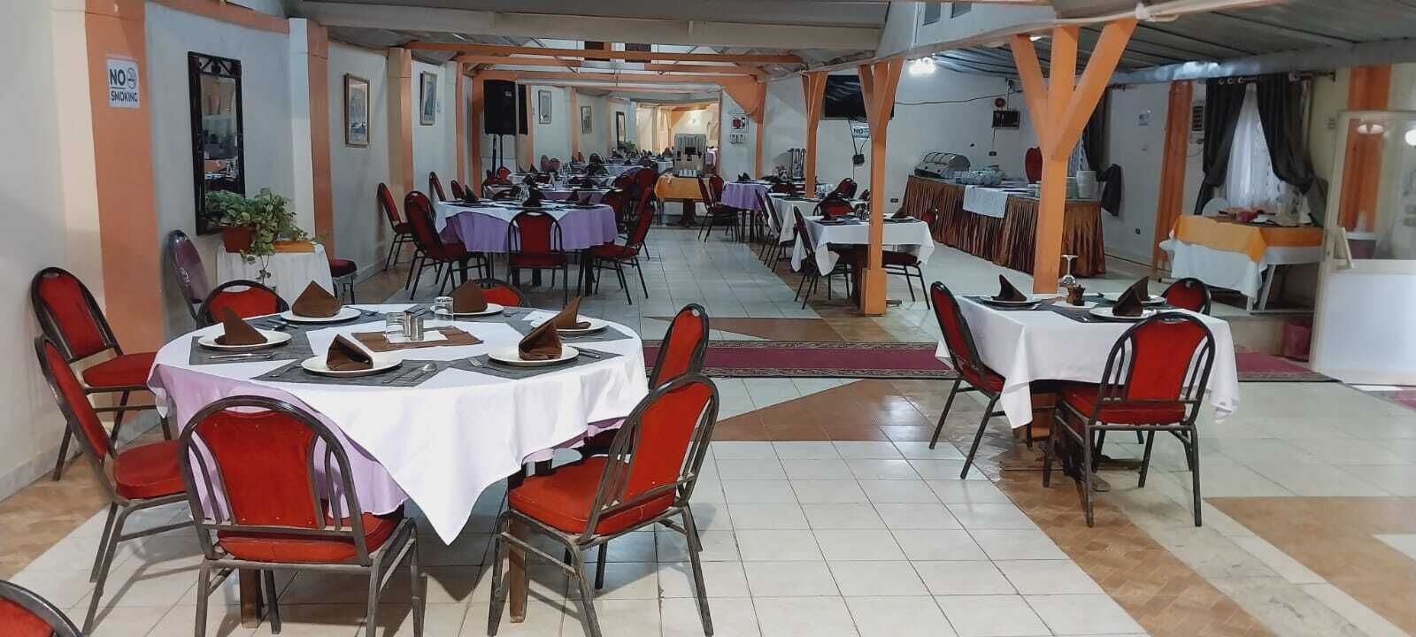 A dining area with multiple tables and chairs, a 'No Smoking' sign, and a tiled floor.