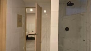 A hallway leading to a bathroom with a shower area. - Hotel Confort 80 Zona Rosa (Bogotá)
