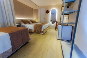 A hotel room with two beds, a desk, a chair, and a built-in wardrobe.