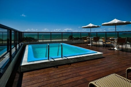 Una piscina al aire libre, sillones reclinables de piscina