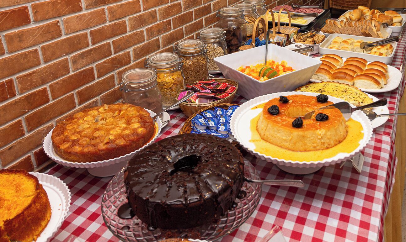 Un tavolo da buffet con diversi cibi e un muro in mattoni sullo sfondo.