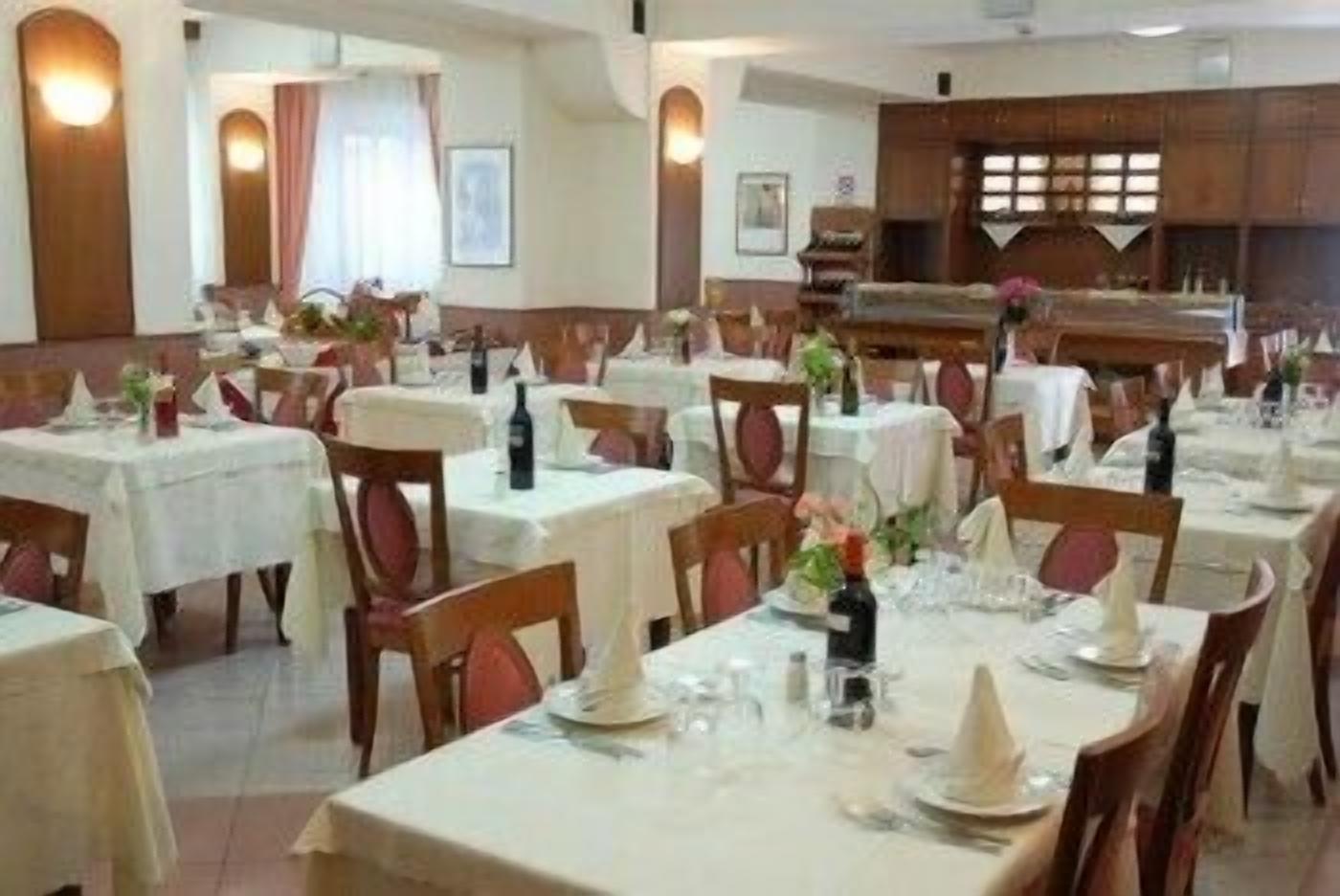 A restaurant with multiple tables set for dining, each with chairs and table settings.