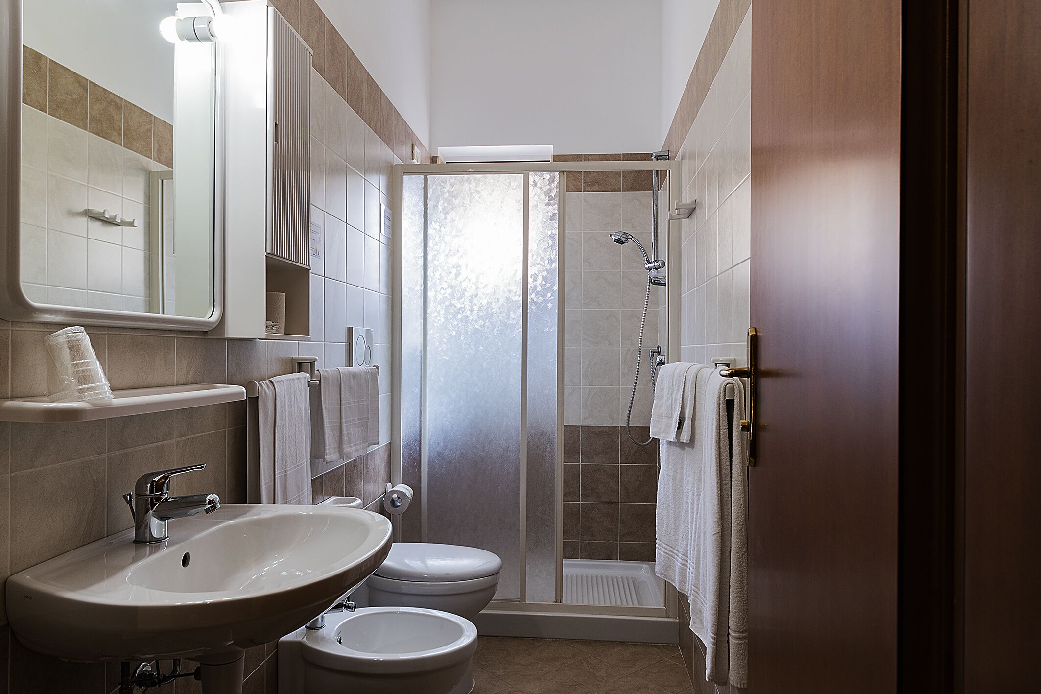 Un bagno con lavandino, WC e doccia.