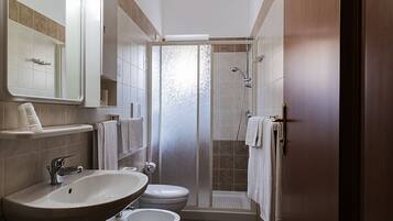 Un bagno con lavandino, WC e doccia.